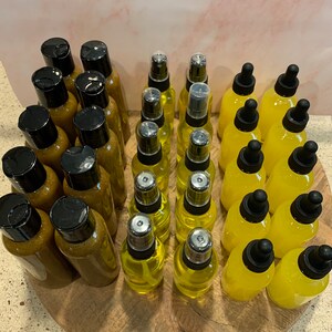 May include: A collection of amber and clear glass bottles with dropper and spray tops. The bottles are arranged in two rows on a wooden surface.