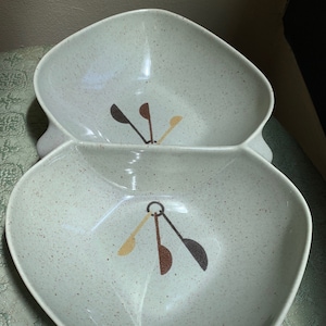 May include: A divided serving dish with a speckled light green glaze. The dish has a unique design with brown and yellow abstract shapes.
