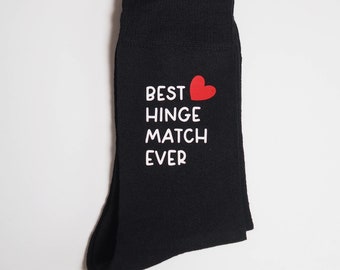 Könnte beinhalten: Schwarze Socken mit einem roten Herzen und dem Text "BEST HINGE MATCH EVER" in Weiß.