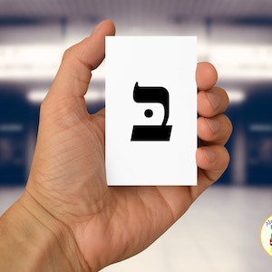 May include: A white card with a black Hebrew letter 'Bet' printed on it. The letter is in a bold, blocky font.