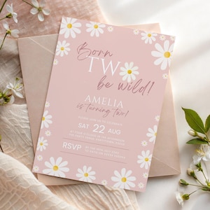 May include: A pink birthday invitation with daisy flower accents and the text "Born TW be wild!" The invitation reads "Amelia is turning two!" and includes the date, time, and RSVP information. The invitation is on a pink background.