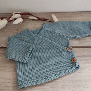 Baby wrap-over bra, hand-knitted layette in celadon merino wool and wooden buttons
