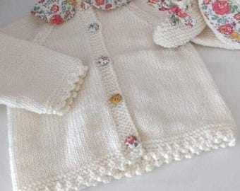 Hand-knitted off-white baby cardigan set and matching booties in off-white merino wool and orange Liberty Felicite