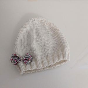 Baby-Erstausstattungsmütze aus weißer Merinowolle, rosa Schleife aus Eloise-Liberty-Stoff