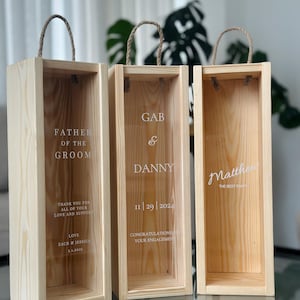 May include: Three wooden boxes with rope handles. The boxes are engraved with the text "Father of the Groom", "Gab & Danny 11|29|2024 Congratulations on your engagement", and "Matthew The Best Pappy".