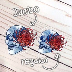 May include: Two watercolor skull stickers with a red chrysanthemum flower. The sticker on the left is labeled "Jumbo" and the sticker on the right is labeled "regular".