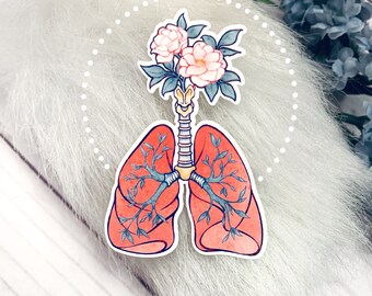 May include: A watercolor illustration of a pair of lungs with a floral bouquet growing from the top. The lungs are pink and the flowers are white with green leaves. The illustration is surrounded by a dotted circle.