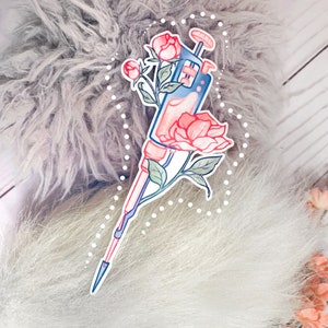 May include: A blue and white pipette with a pink flower and leaves. The pipette is surrounded by a white dotted circle.