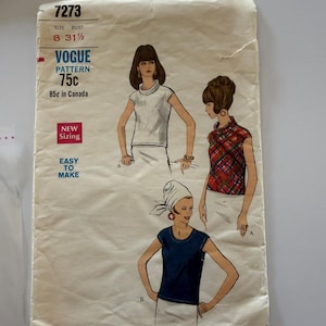May include: A Vogue sewing pattern envelope labeled 7273 for size 8 with a 31.5 inch bust. The cover features illustrations of three sleeveless tops: a solid white mock neck, a red and green plaid mock neck, and a solid navy blue crew neck.