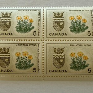 May include: A block of four Canadian postage stamps. Each stamp features a coat of arms, yellow flowers, and the number 5. The text "MOUNTAIN AVENS" and "CANADA" are visible.