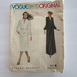 May include: Vintage Vogue Paris Original sewing pattern featuring two dress designs by Pierre Balmain. The pattern envelope is off-white with illustrations of the dresses and text in blue and black.
