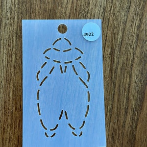 May include: A blue plastic stencil with a dashed line design of a UFO. The stencil has a round hole at the top and a white circle with the number "#922" printed on it.
