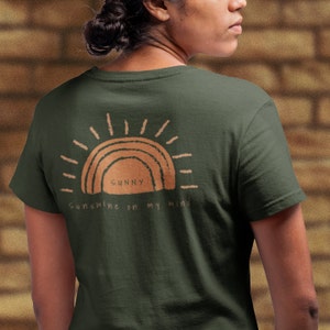 Puede incluir: Una camiseta verde oscuro con un gr&aacute;fico de sol marr&oacute;n y el texto "Sunny Sunshine on my mind".