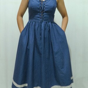May include: A blue and white polka dot dress with a lace trim and a lace-up bodice.