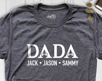 May include: A dark gray t-shirt with the word "DADA" printed in white with two white dumbbells on either side of the "A". Below the word "DADA" is the text "JACK • JASON • SAMMY" in white.