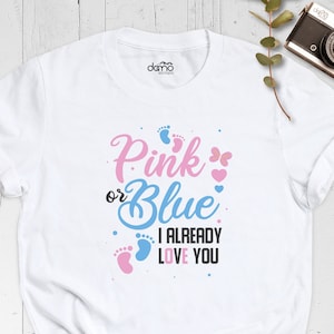 May include: White t-shirt with the text "Pink or Blue I Already Love You" in black, pink, and blue. The text is surrounded by pink and blue footprints and hearts.