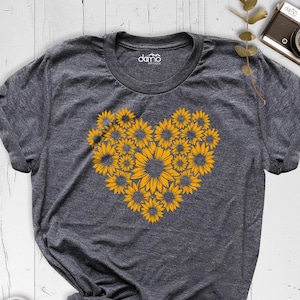 May include: A gray t-shirt with a heart-shaped design made of yellow sunflowers.