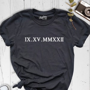 May include: A dark gray t-shirt with white text that reads "IX.XV.MMXXII".