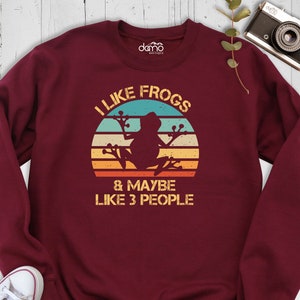 May include: Burgundy sweatshirt with a vintage-style graphic of a frog sitting on a branch with the text "I like frogs & maybe like 3 people".