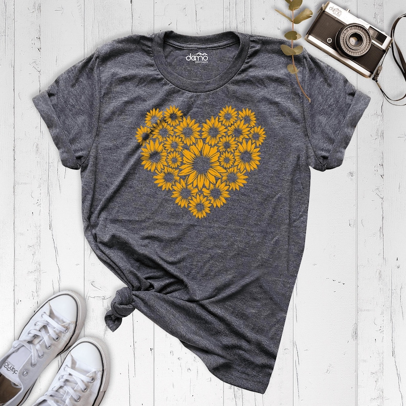 May include: A gray t-shirt with a heart-shaped design made of yellow sunflowers.