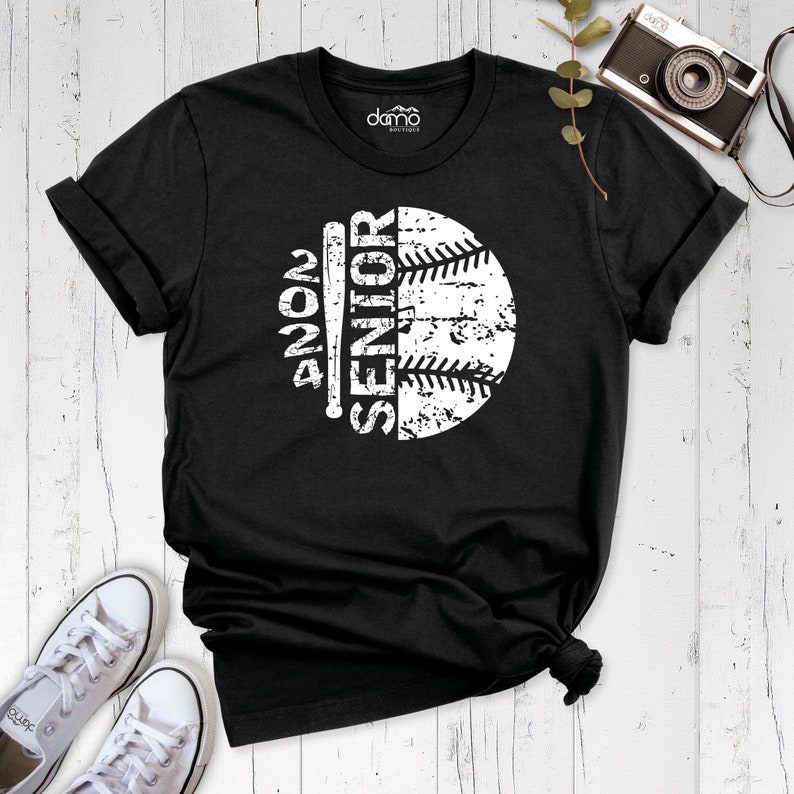 Peut inclure: T-shirt noir avec un graphique blanc d'un ballon de baseball et d'une batte avec le texte "Senior 2024".