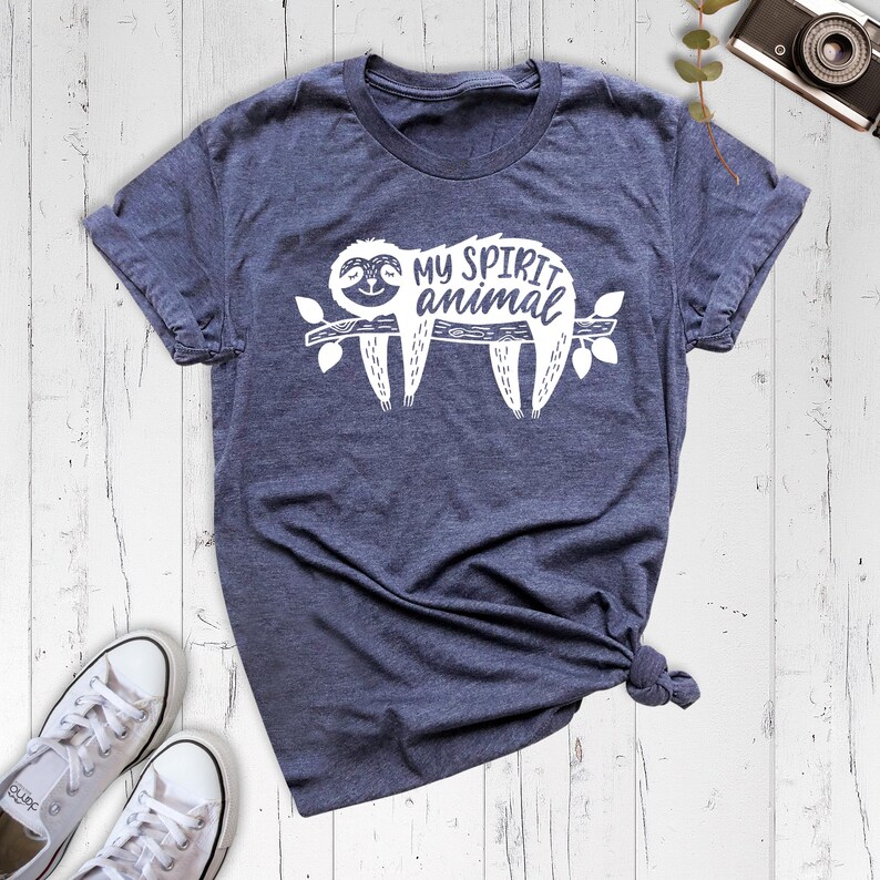 May include: A dark blue t-shirt with a white graphic of a sloth on a branch. The text "My spirit animal" is printed above the sloth.