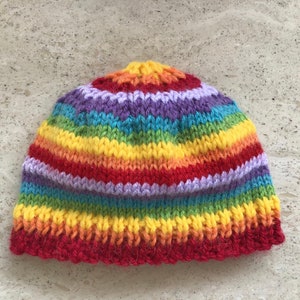 May include: A rainbow striped knitted hat with a red brim.