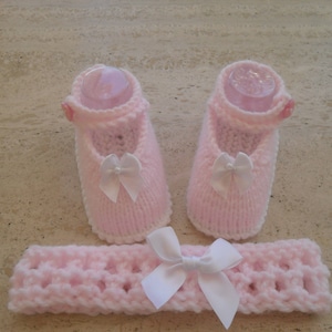 Puede incluir: Un conjunto de botines de bebé de punto rosa con lazos blancos y una diadema rosa a juego con un lazo blanco.