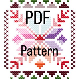 Può includere: Un motivo a punto croce con un disegno floreale centrale nei toni del rosa, rosso, viola e arancione. Le parole "PDF Pattern" sono visualizzate in nero. Il bordo presenta un motivo ripetuto di croci rosso scuro e verdi.