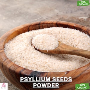 May include: A wooden bowl filled with white psyllium husk powder. A wooden spoon scoops out the powder. The text "100% Organic" is on a green label in the top right corner. The text "Psyllium Seeds Powder" is in large letters below the bowl. The text "100% Organic" is on a green label in the bottom right corner.