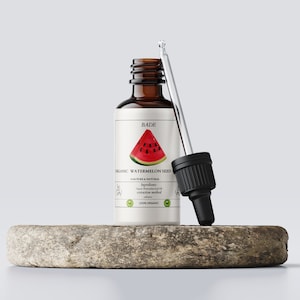 May include: A brown glass bottle with a dropper filled with organic watermelon seed oil. The bottle has a white label with the text "BLADE ORGANIC WATERMELON SEED OIL PURE & NATURAL" and a picture of a slice of watermelon.