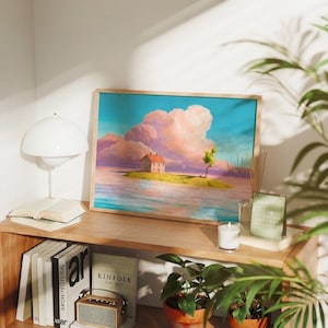 May include: A framed art print shows a fantasy landscape with a house on an island, a tree, and pink clouds against a blue sky. The artwork is in a wooden frame and sits on a wooden shelf with books, a lamp, and plants.