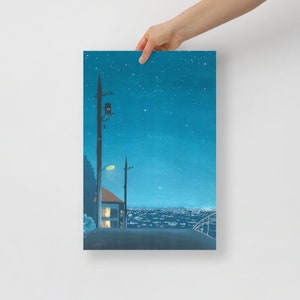 May include: A print of a nighttime cityscape with a starry sky. The artwork depicts a road leading towards a town with lights, a house, and utility poles. The color palette is dominated by shades of blue and teal.