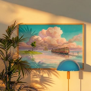 May include: A framed artwork depicts a train traveling through a serene landscape with a pink and blue sky. The train is red and brown, and the artwork is framed in a light wood. A blue lamp with a gold base is in the foreground.