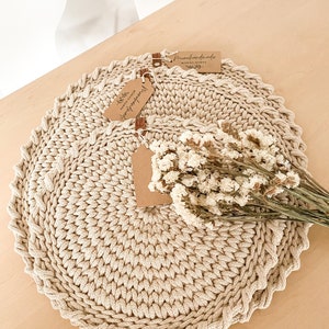 Puede incluir: Dos manteles individuales de crochet beige con una etiqueta marr&oacute;n que dice "Handmade" y una etiqueta que dice "With love from Monika Nowak".