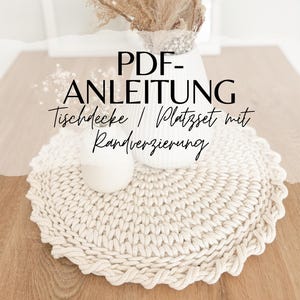 Könnte beinhalten: PDF-Anleitung zum Häkeln eines Tischläufers und Platzsets mit dekorativem Rand. Das Bild zeigt eine Nahaufnahme eines gehäkelten Platzsets aus weißem, strukturiertem, seilartigem Garn.