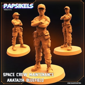 Puede incluir: Una miniatura impresa en 3D de una miembro femenina de la tripulación espacial que lleva un mono de trabajo, una gorra y botas. La miniatura está en posición de brazos cruzados y está de pie sobre una base circular. El texto "SPACE CREW MAINTENANCE ANATALYA BLUEFIELD" está impreso debajo de la miniatura.