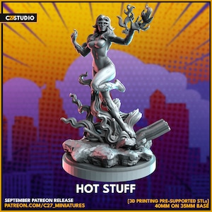 May include: A gray 3D printed miniature of a female superhero figure with flames, standing on a rocky base. The figure is wearing a white costume with a black belt and a mask. The text "HOT STUFF" is printed below the figure.