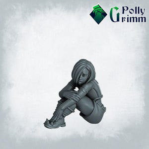 May include: A gray painted miniature figurine of a woman sitting with her legs crossed and her arms wrapped around her knees. She has short, straight hair and is wearing a short-sleeved shirt and shorts.