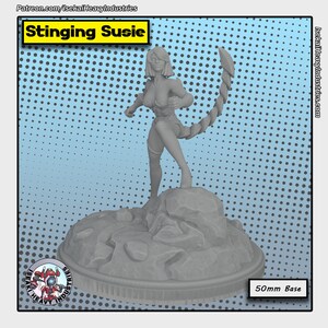 May include: Gray 3D printed miniature of a female figure with a scorpion tail, standing on a rocky base. The figure is titled "Stinging Susie".