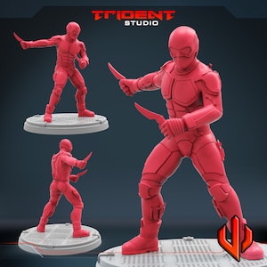 Pu&ograve; includere: Una action figure rossa di un soldato futuristico che tiene due coltelli. La figura indossa un elmetto e un'armatura rossi. La figura &egrave; in piedi su una base grigia.