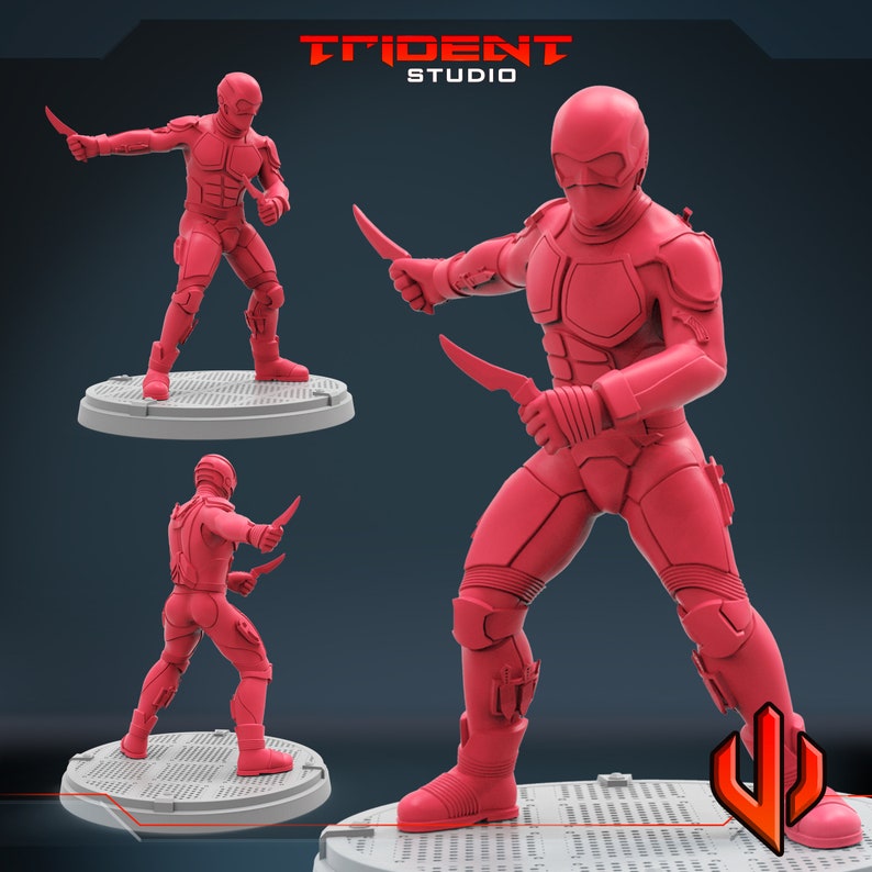 Pu&ograve; includere: Una action figure rossa di un soldato futuristico che tiene due coltelli. La figura indossa un elmetto e un'armatura rossi. La figura &egrave; in piedi su una base grigia.
