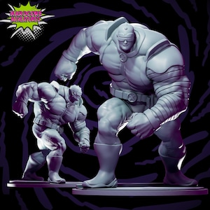 May include: Two gray plastic figurines of a muscular superhero with a helmet and goggles. The larger figurine is standing with one leg forward and the other leg back. The smaller figurine is standing with both legs together. The figurines are on a white base.