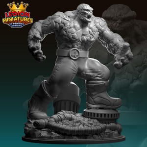 Op de afbeelding: Een grijs, steenachtig figuur met een getextureerd oppervlak, staand op een basis met pijpen en puin. Het figuur heeft een riem met een symbool erop. Het figuur is een 3D-geprint miniatuur.