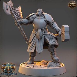Może przedstawiać: Szara plastikowa figurka miniaturowa wojownika w zbroi, trzymającego dużą siekierę i młot. Figurka stoi na okrągłej podstawie. Figurka jest częścią serii "Protectors of the Cleansing Fire".
