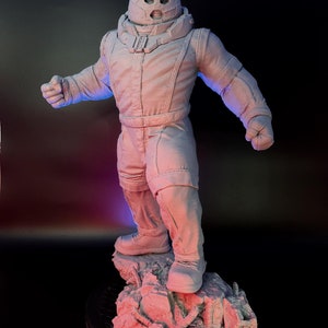 May include: A white, unpainted plastic figurine of the Marvel Comics character, The Juggernaut, standing on a rocky base. The figurine is posed in a dynamic stance with one arm raised and the other bent at the elbow.