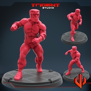 May include: Three red plastic action figures in fighting poses. The figures are wearing helmets and have detailed muscle definition. The figures are standing on black bases with a grid pattern.