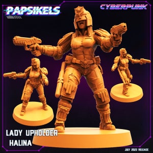 May include: A 3D printed miniature of a female cyberpunk character, a Lady Upholder named Halina, holding a gun and a baton. The miniature is painted in orange and brown tones and is standing on a circular base. The text "Lady Upholder Halina" is printed below the base.
