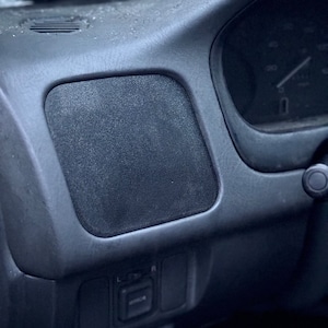 Può includere: Primo piano dell'interno di un'auto, che mostra un cruscotto grigio con una griglia dell'altoparlante e un pannello di controllo con pulsanti etichettati "L" e "R".