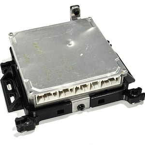 Puede incluir: Una unidad de control automotriz plateada con una carcasa de plástico negro y un conector con múltiples pines. La unidad tiene texto en la parte superior que dice "12V 500CC".
